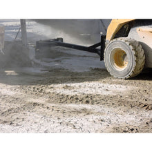 Berlon Industries material pusher pushing spilled material on a skid steer