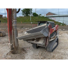 Maxx Attachments side dump bucket tipping on a compact track loader at a job site