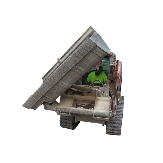 Maxx Attachments side dump bucket tipped to the side on a compact track loader