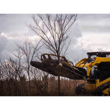 Maxx Attachments Vortex brush cutter raised on a compact track loader in a stand of trees
